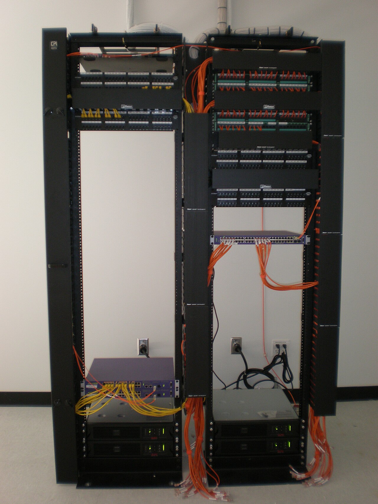 Server rack with organized orange network cables running through patch panels